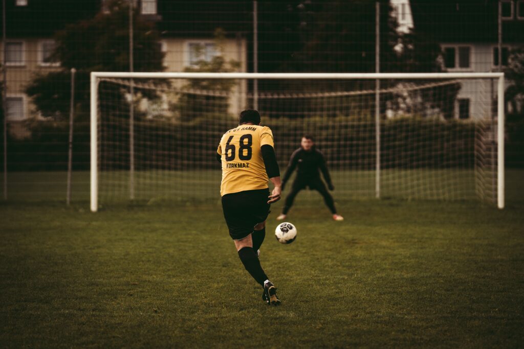 Two Mans Playing Football Wearing Black And Yellow Jersey.